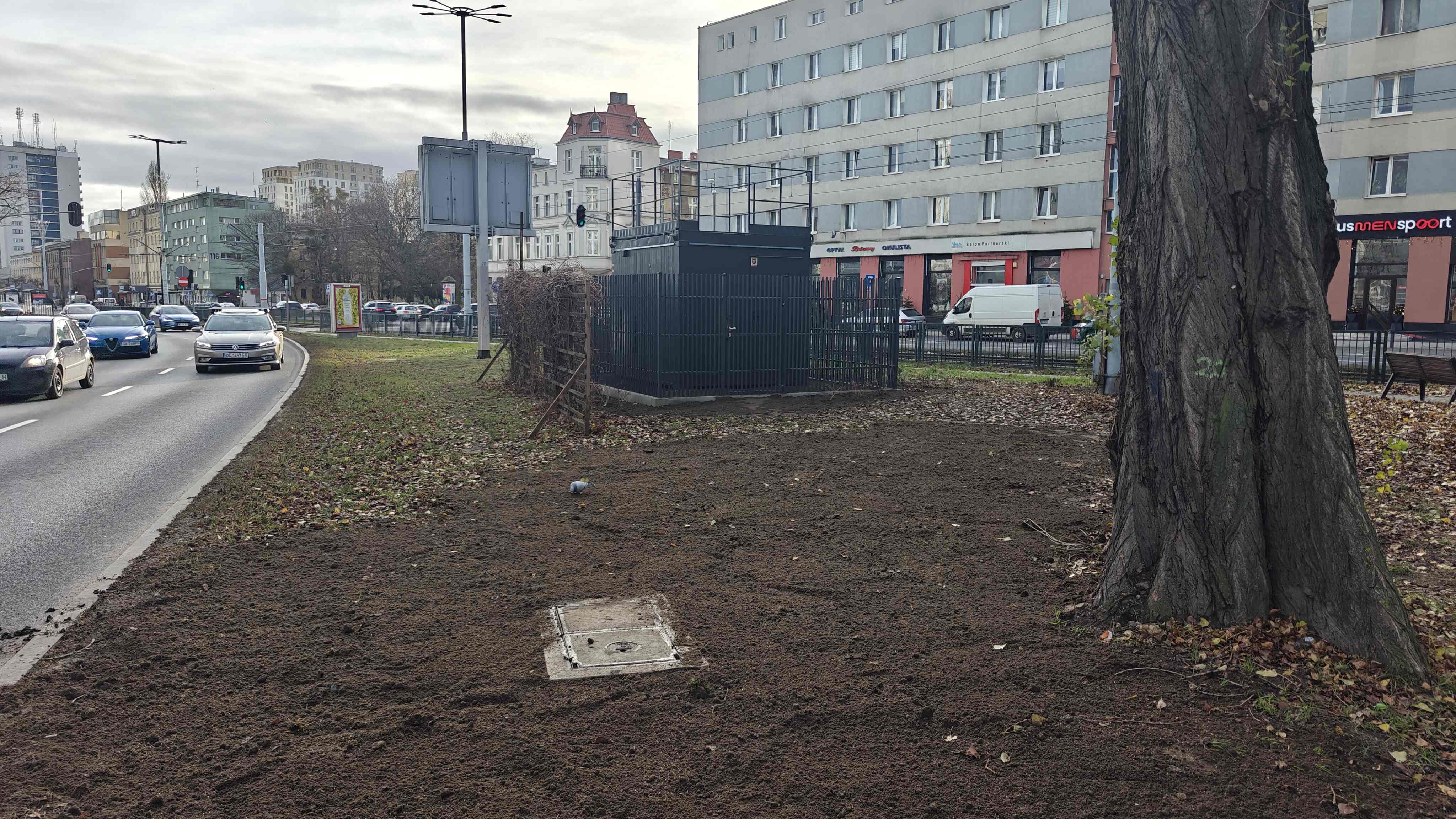 Widok na stację komunikacyjna w kierunku południowym, stacja znajduje się w centrum obrazka, otoczona płotem.